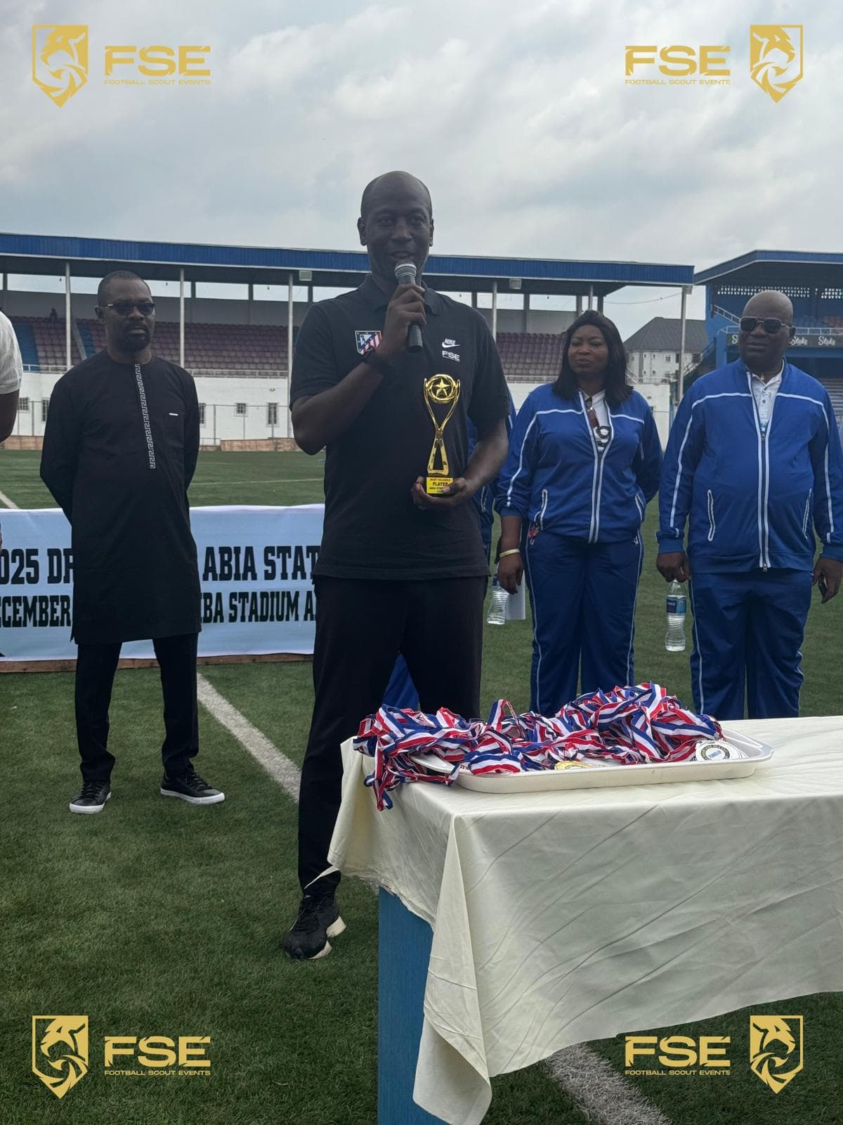 Wally Dieng au micro avec trophée et médailles, Abia Stadium, Nigeria
