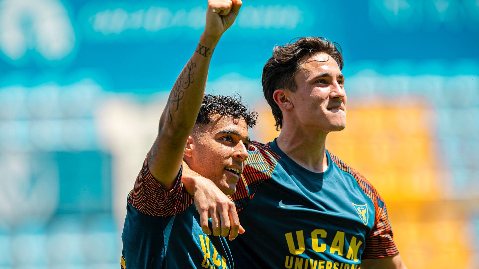 Two UCAM players celebrating a goal with a raised fist